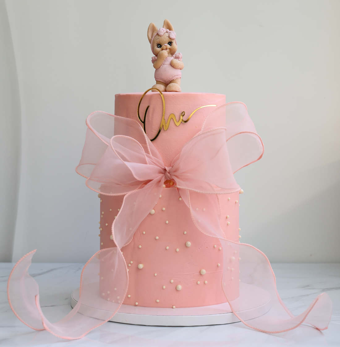 Two-tier cake with a bow for a girl