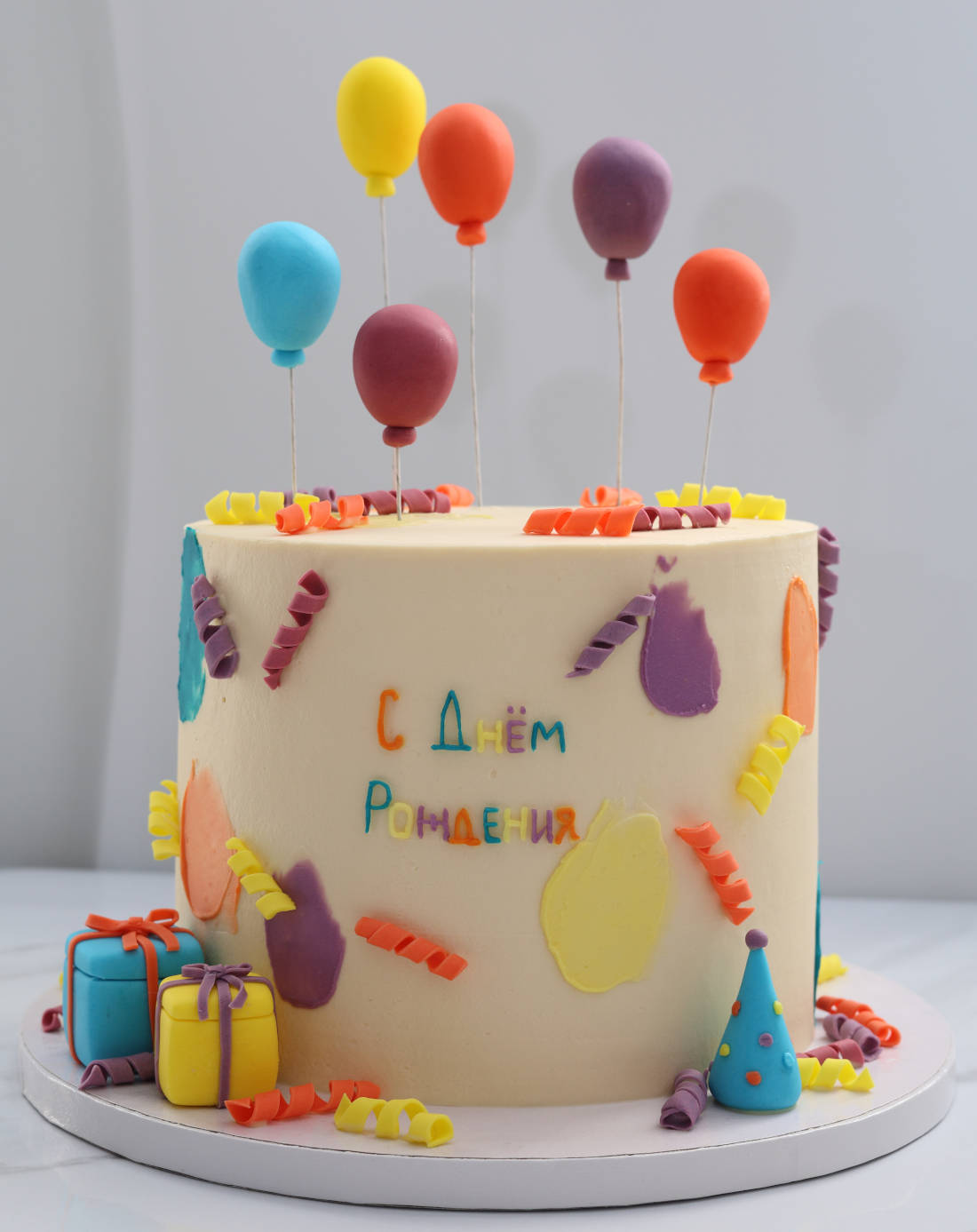 Balloons and birthday gifts on a festive cake