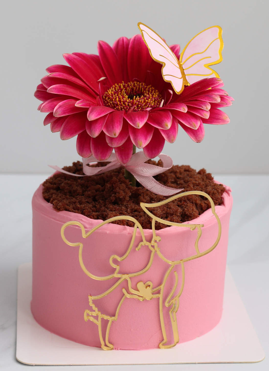 Butterfly, boy and girl on the cake with gerbera