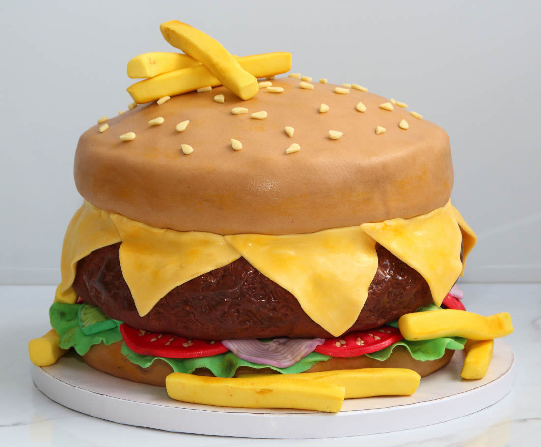 Sweet burger cake with meat, cheese, onions and tomatoes