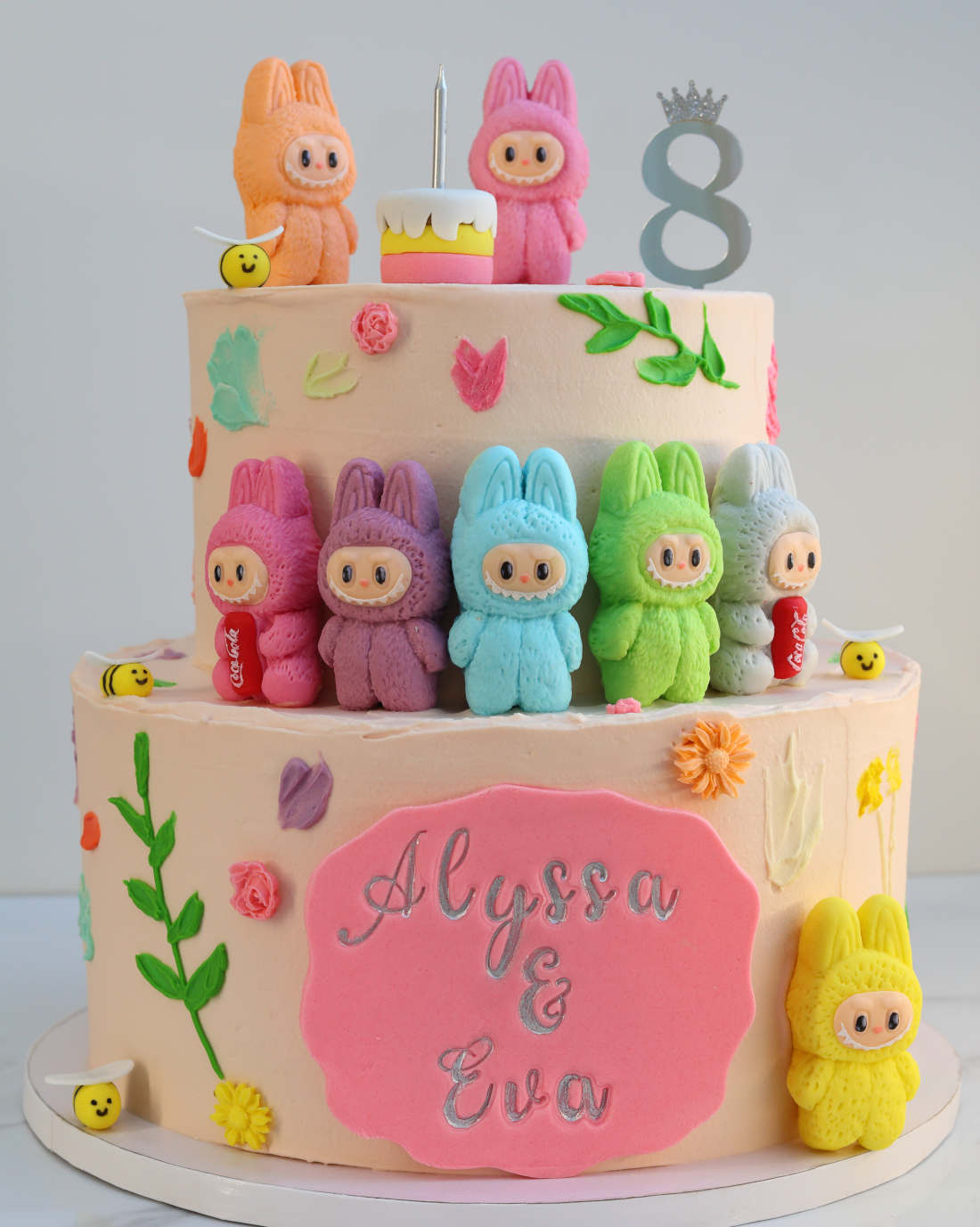 Two-tier cake with multicolored Labubu figurines