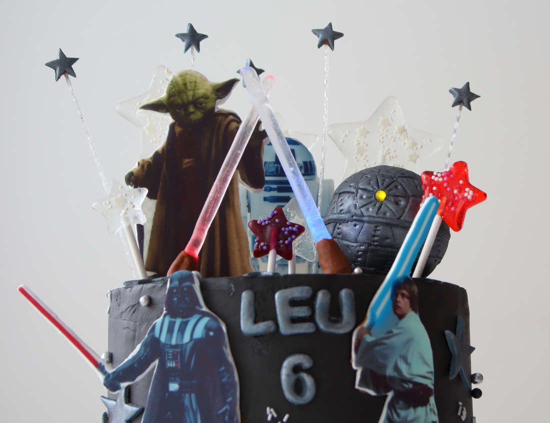 Isomalt lollipops and glowing swords on a Star Wars cake