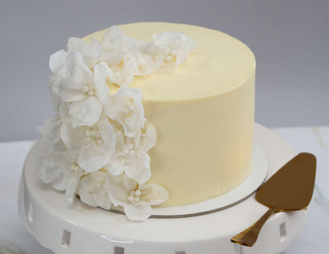 White cake for birthday or wedding with wafer paper flowers